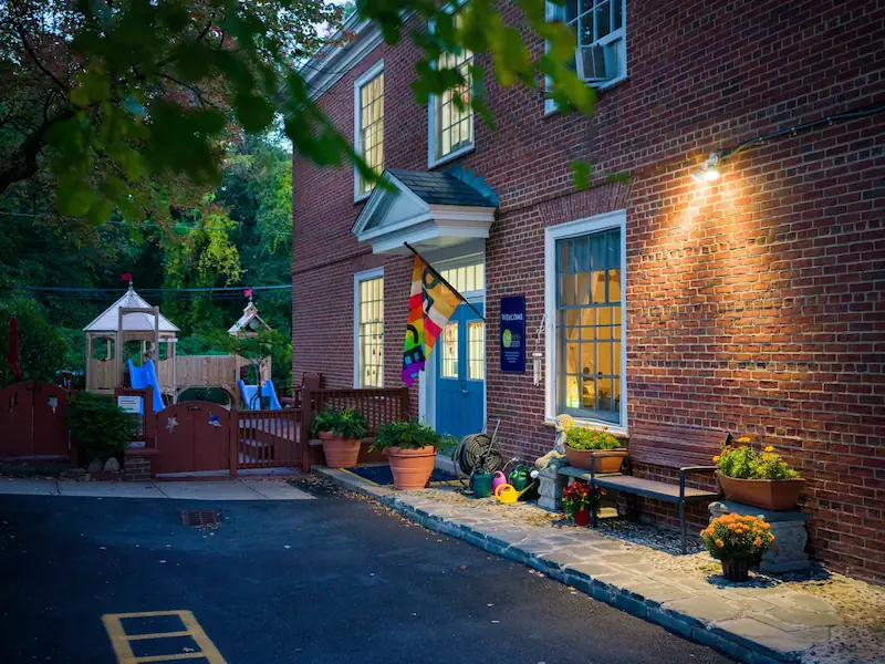 Photo of the exterior of the school building, with a peace flag.