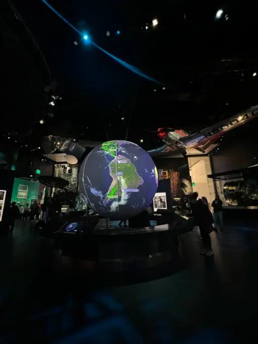 An illuminated globe is at the centre of a dark room.