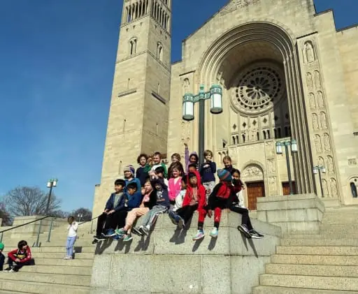 Photo from a school trip with a group of students posing outside a shrine.