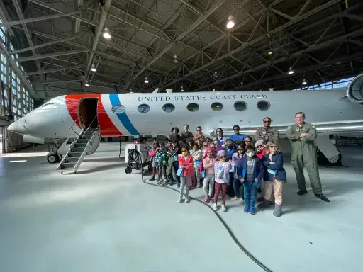A group of students pose for the camera during a tour at the Coast Guard Air Station.
