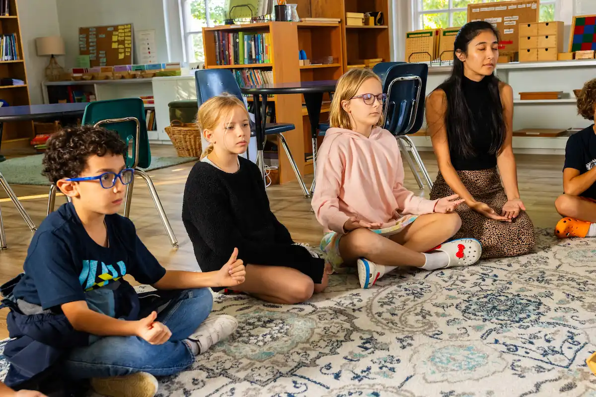 A group of students are sat in a circle meditating