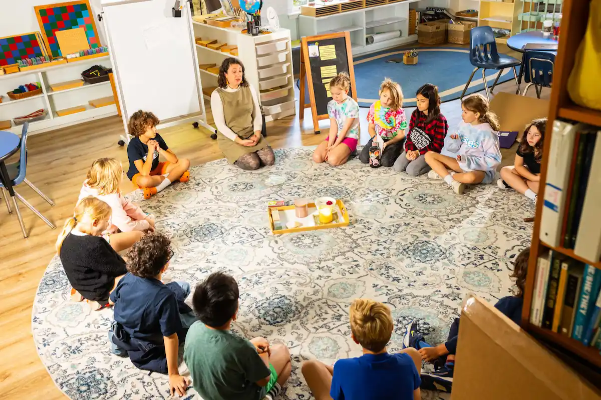 A group of students are sat in a circle on the floor with healthy snacks in the center