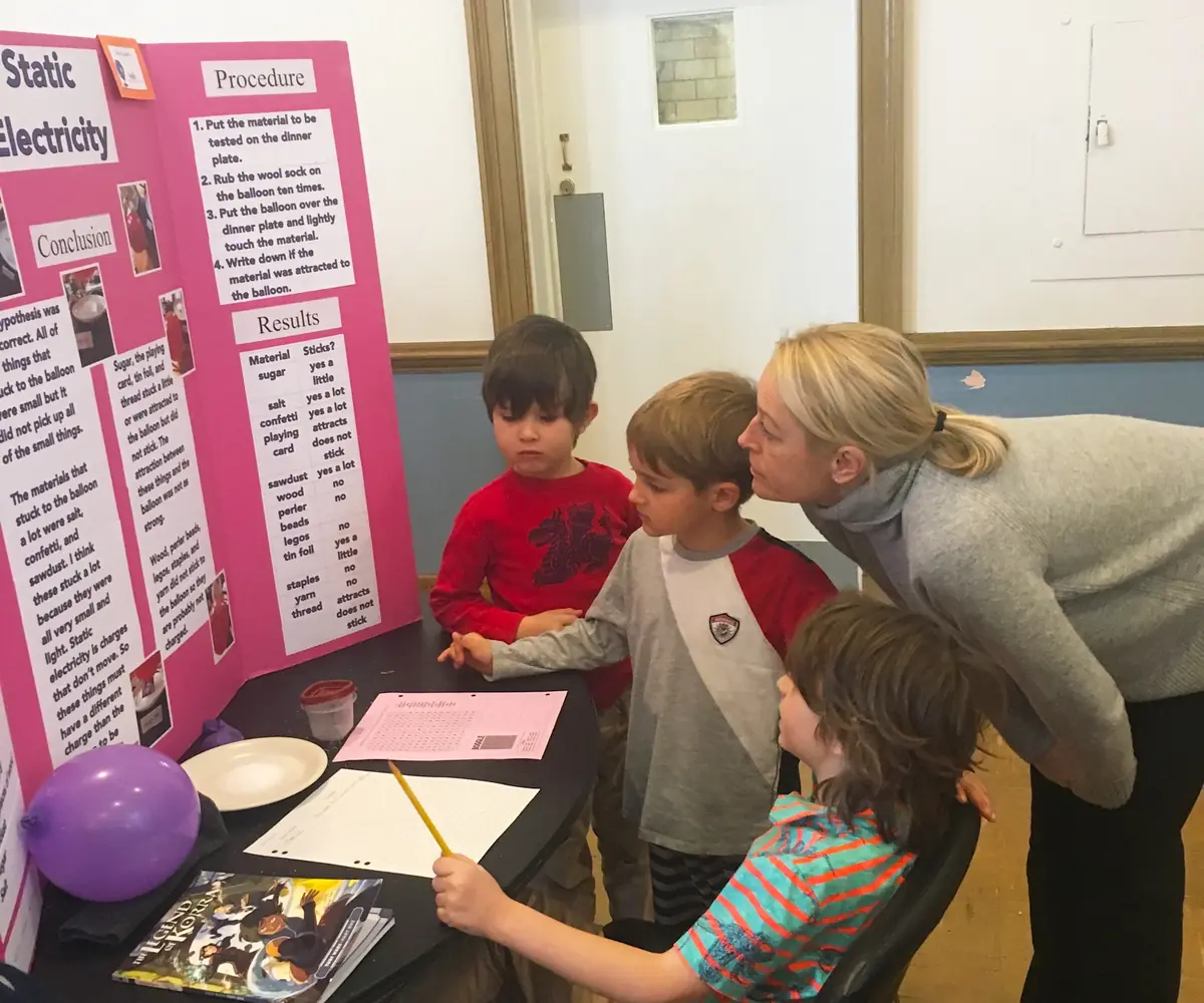 Young students are explaining their project to an adult.