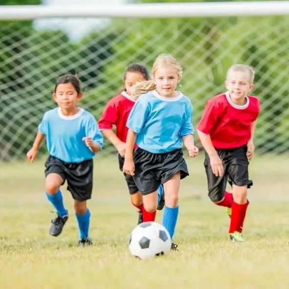 Some young students are playing soccer.