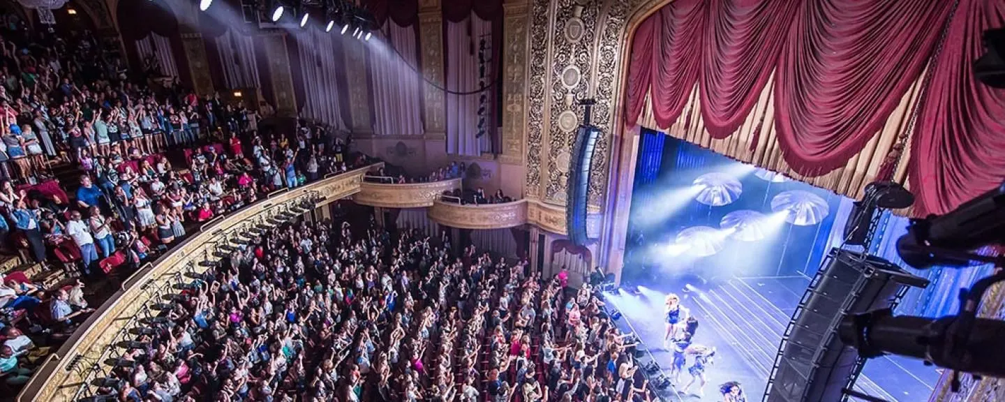 Photo of a theater show with a packed audience