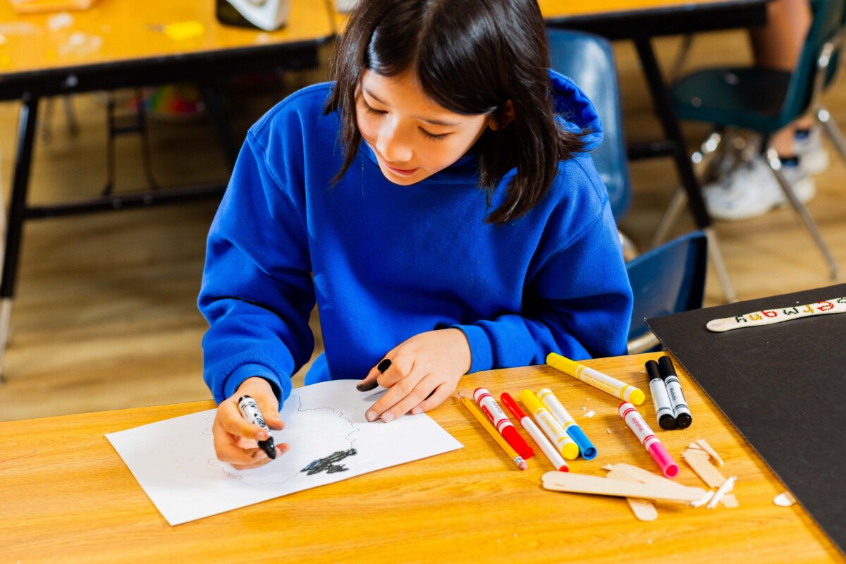 A student draws on a piece of paper